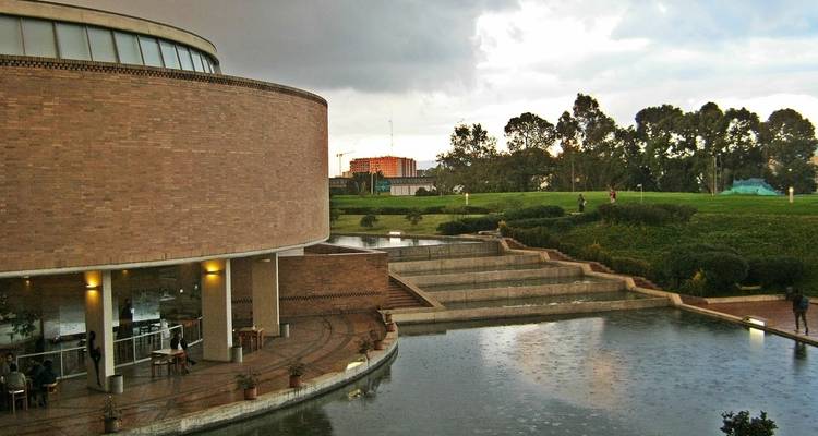 Modern circular building by water.