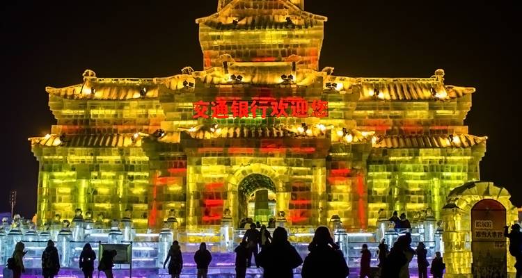 Beleuchtete Eisskulptur mit Menschen in Harbin.