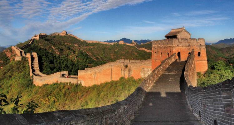 Vista de la Gran Muralla China con montañas al fondo.