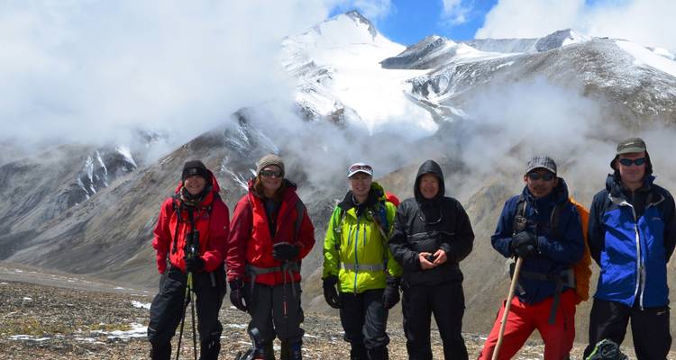 Groupe de randonneurs avec des montagnes enneigées en arrière-plan.