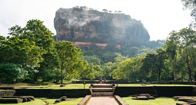 La masiva fortaleza rocosa de Sigiriya se eleva sobre exuberantes jardines verdes después de la lluvia matutina.