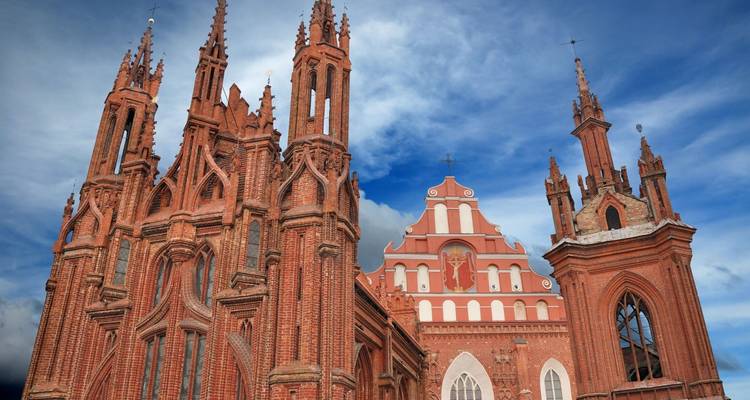 Une église gothique avec une maçonnerie complexe sous un ciel dramatique.