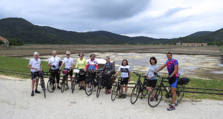 Cyclistes posant devant un paysage vallonné.