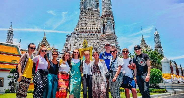 Groupe de touristes devant un temple grandiose.