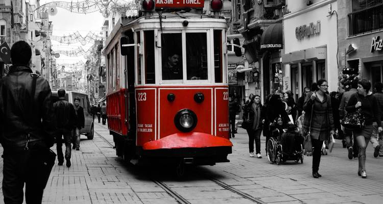 Historische Straßenbahn auf der Istiklal-Allee in Istanbul mit flanierenden Menschen.