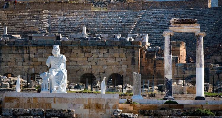 Ruinas antiguas con columnas y una estatua.
