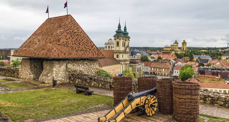 Les canons historiques et les fortifications en osier surplombent les toits carrelés et les clochers d'église à Eger, en Hongrie.