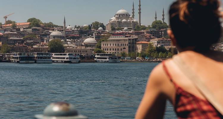 Un voyageur regarde à travers le Bosphore vers l'horizon d'Istanbul couronné de dômes et de minarets.
