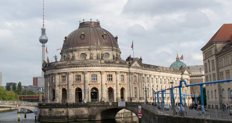 El Museo Bode y la Torre de Televisión de Berlín se elevan sobre el río Spree bajo un cielo nublado.