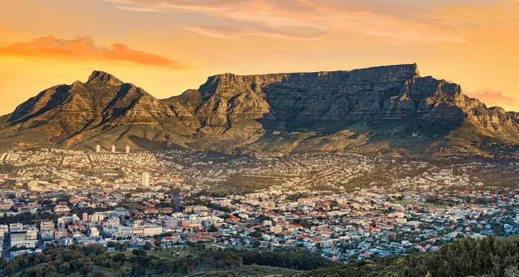 Panoramisch zonsondergangzicht over Kaapstad met de Tafelberg die boven de stad en kustlijn uittorent.