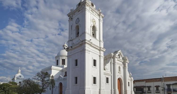 White-washed colonial church with cloudy sky backdrop.