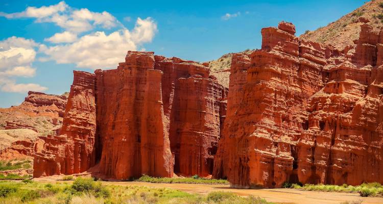 Hautes formations rocheuses rouges sous un ciel bleu.