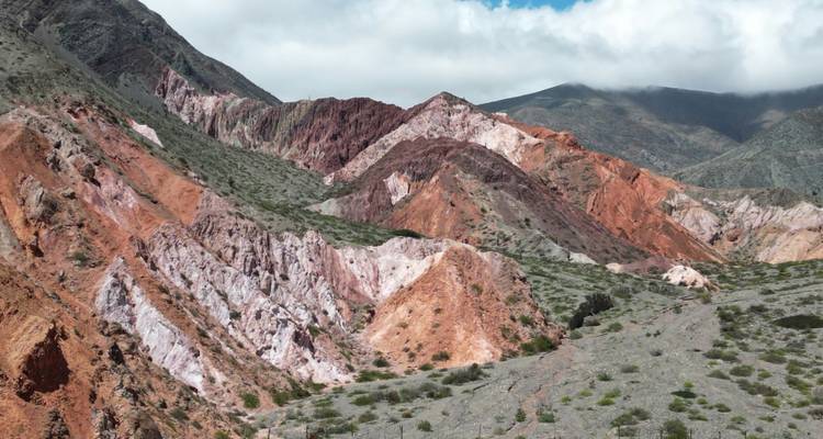 Montagnes colorées en couches avec une végétation clairsemée.