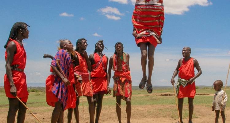 Groupe de personnes en vêtements traditionnels massaï exécutant une danse sautée.