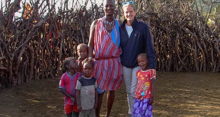 Famille souriante avec enfants dans un cadre de village traditionnel.