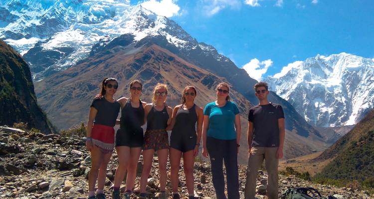 Grupo de excursionistas con montañas nevadas al fondo.