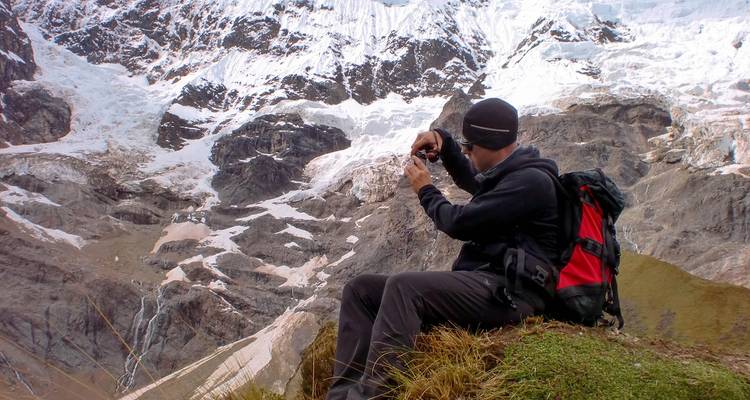 Hombre fotografiando un vasto paisaje montañoso.
