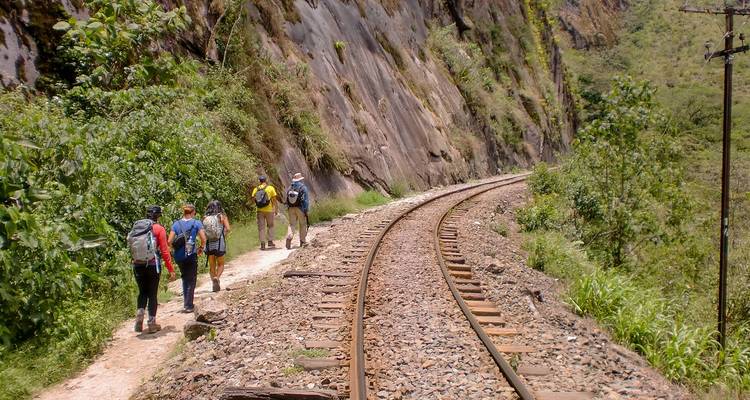 Excursionistas caminando por una vía férrea.