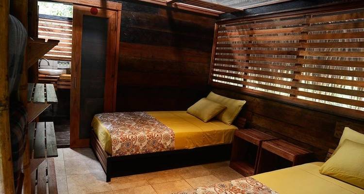 Interieur van een houten kamer met twee bedden.