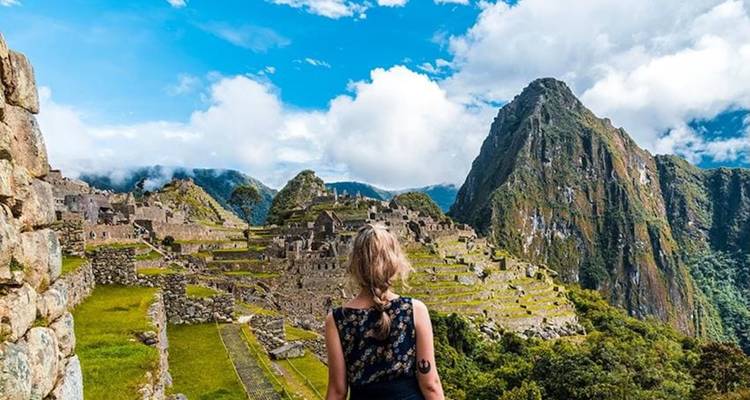 Une personne debout devant les ruines du Machu Picchu.