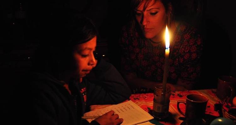 Gente leyendo a la luz de las velas.