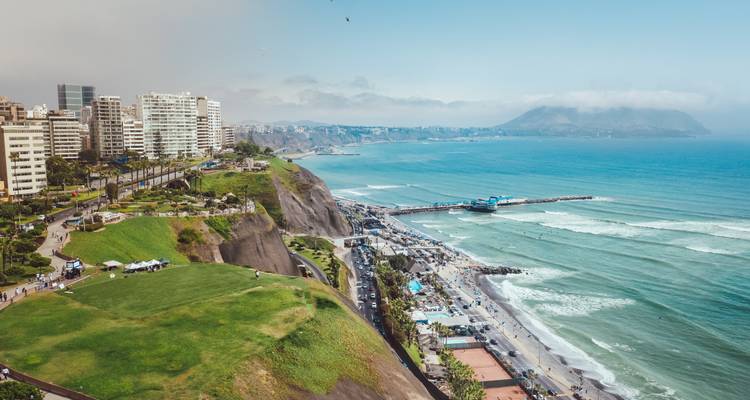 Les parcs en hauteur et l'autoroute côtière surplombent l'océan Pacifique et la jetée le long du littoral de Miraflores à Lima par une journée dégagée.