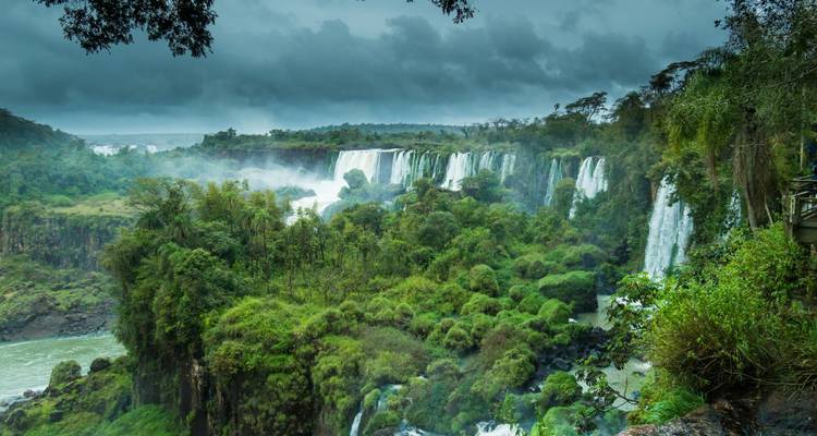 Uitgestrekt uitzicht op de torenhoge Iguazu-watervallen te midden van weelderig groen.