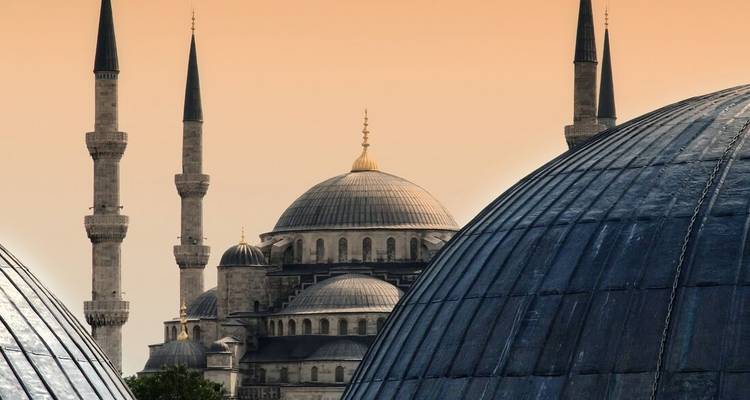 Gros plan d'une mosquée avec des minarets au coucher du soleil.