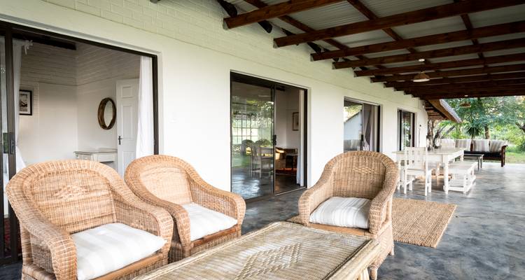 Open-air seating area with wicker furniture.