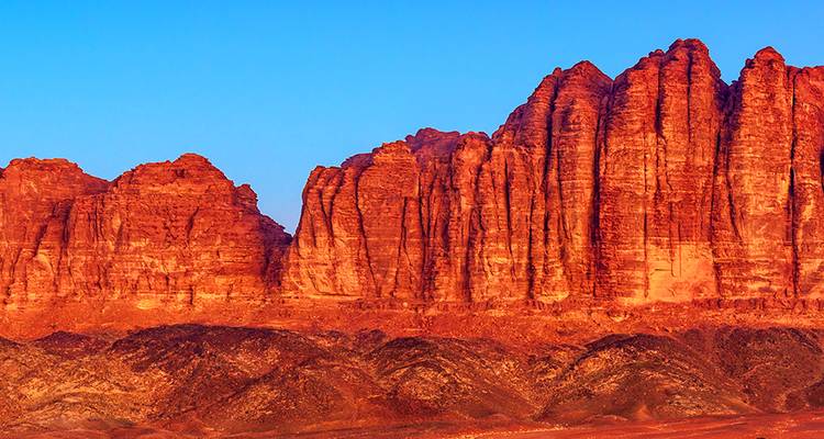 Rotsformaties in de Wadi Rum woestijn verlicht door zonsondergang.