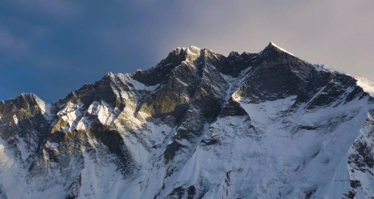 Een bergtop onder een dramatische gedeeltelijk bewolkte lucht.