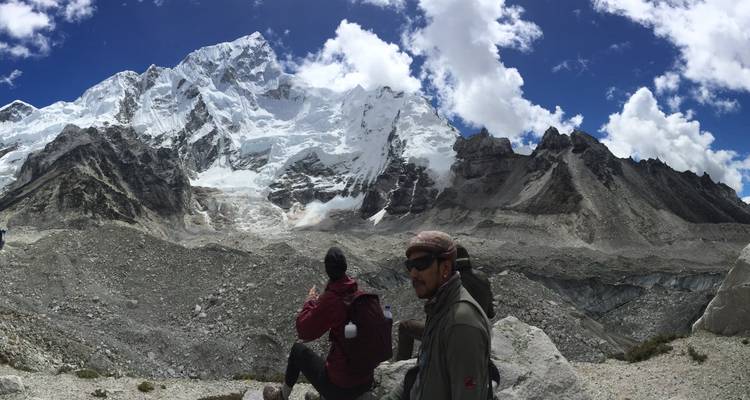 Twee mensen in buitenkleding zittend bij een berglandschap.