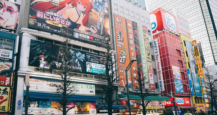 Rue urbaine animée avec des enseignes colorées et des gens qui marchent.