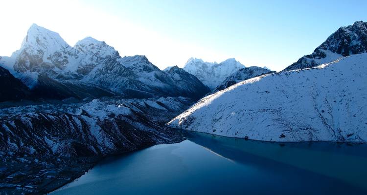 Vista panorámica de montañas nevadas y lago.