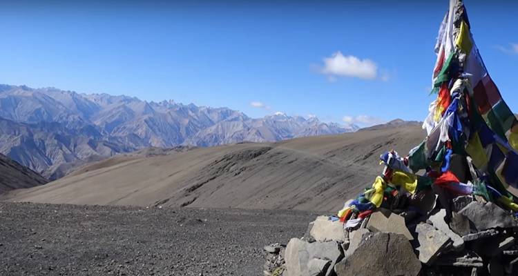Paysage de montagne avec drapeaux de prière colorés.