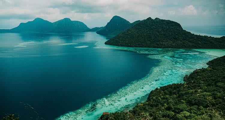 Vue aérienne panoramique des récifs turquoise et des îles couvertes de jungle dans la mer bleu cristallin du Sabah