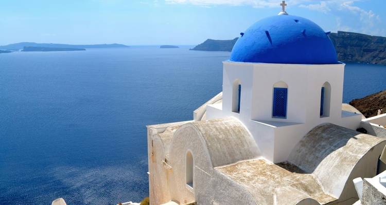 Iconische kerk met blauwe koepel met uitzicht op de oceaan.
