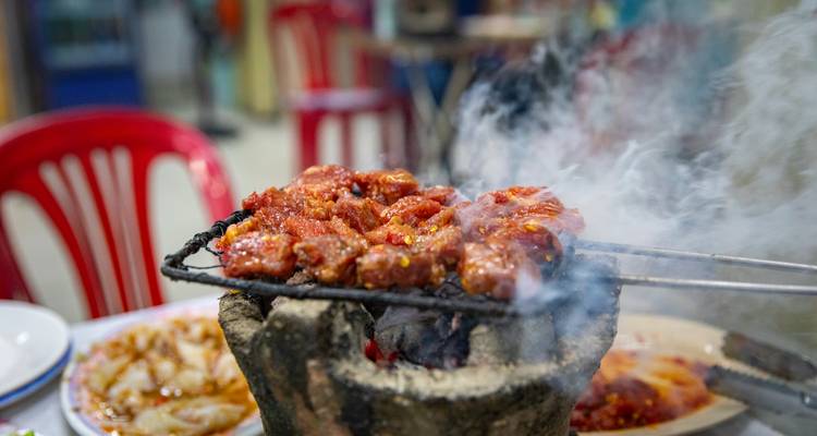 Heerlijk gegrild vlees aan een spies met stoom en rook die opstijgt.