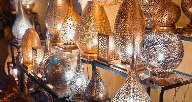 Exposición de lámparas de metal con diseño intrincado, iluminadas.