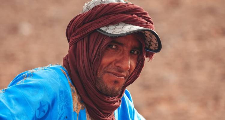 Primer plano de un hombre llevando ropa tradicional y una gorra.