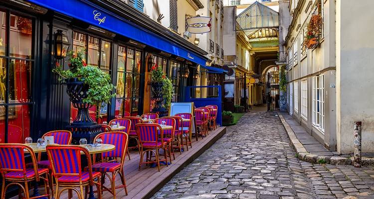 Rue confortable à Paris avec des cafés et des pavés.