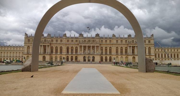 Grand palais avec une arche au premier plan.