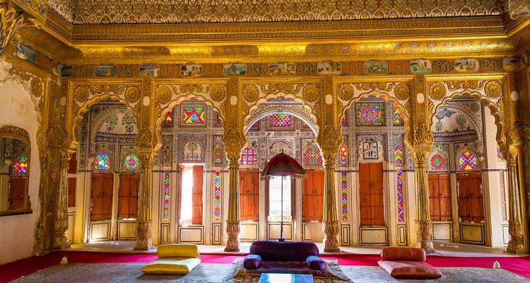 Luxurious, ornately decorated interior with colorful windows and intricate designs.