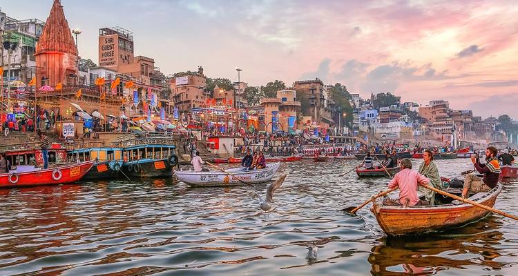Barcos en un río con edificios coloridos al fondo.