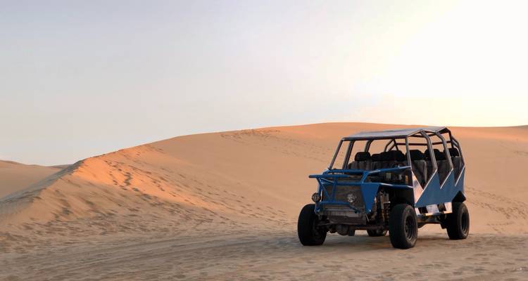 Buggy bleu garé sur les vastes dunes de sable doré au coucher du soleil à Huacachina