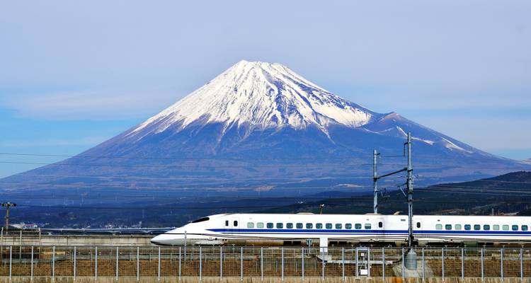 El monte Fuji con un tren a toda velocidad en primer plano.