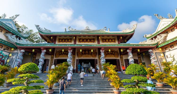 Un temple traditionnel avec des visiteurs qui montent les escaliers.
