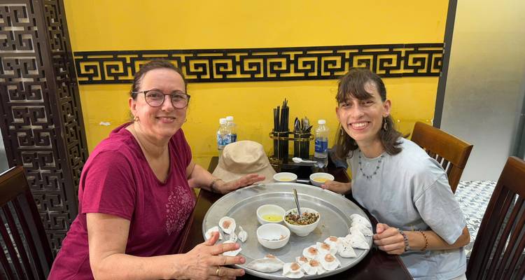 Deux femmes savourant un repas dans un restaurant, assises devant une grande assiette de boulettes.