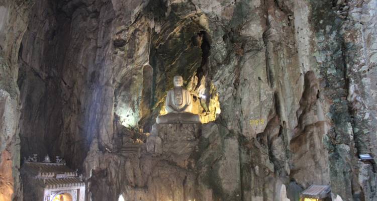 Statue de Bouddha sculptée dans une paroi rocheuse à l'intérieur d'une grotte.