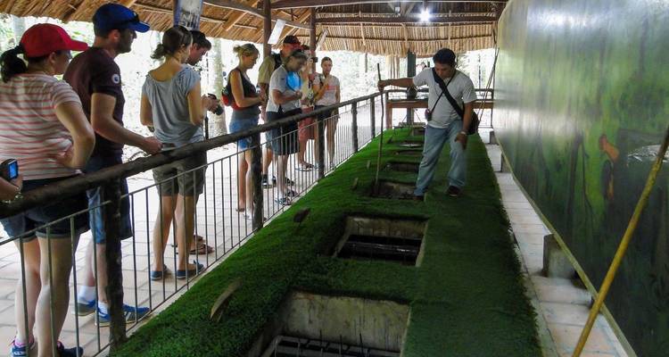 Turistas conociendo un lugar histórico con túneles subterráneos.